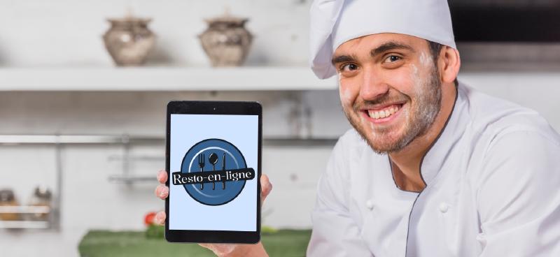 un restaurateur souriant montrant le logo de l'application resto-en-ligne sur tablette