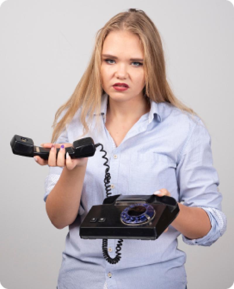 une femme enervée portant un vieux téléphone noir